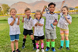 Children in soccer clothes with medals