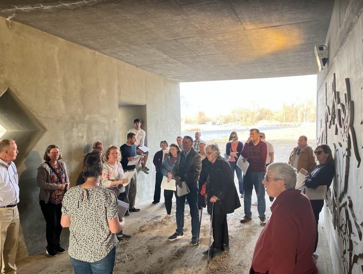 Group of adult in a cement corridor listening to an instructor