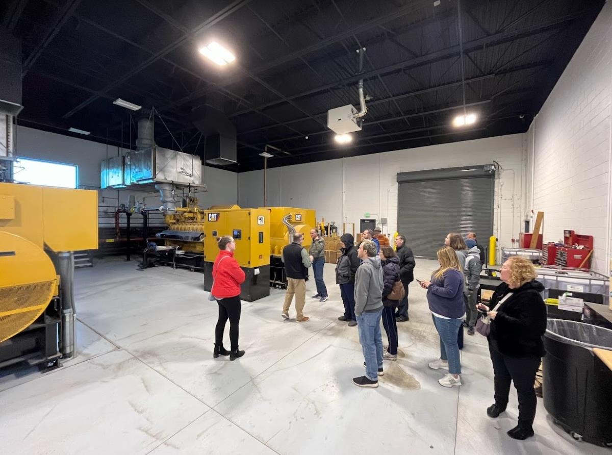 A group of adults in a power plant control room