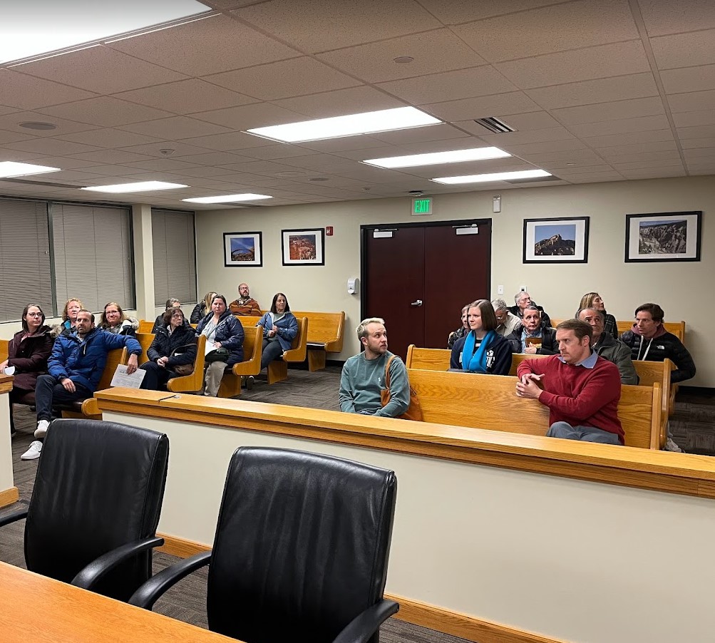 A group of people sitting the the spectator section of the Provo Justice Courtroom