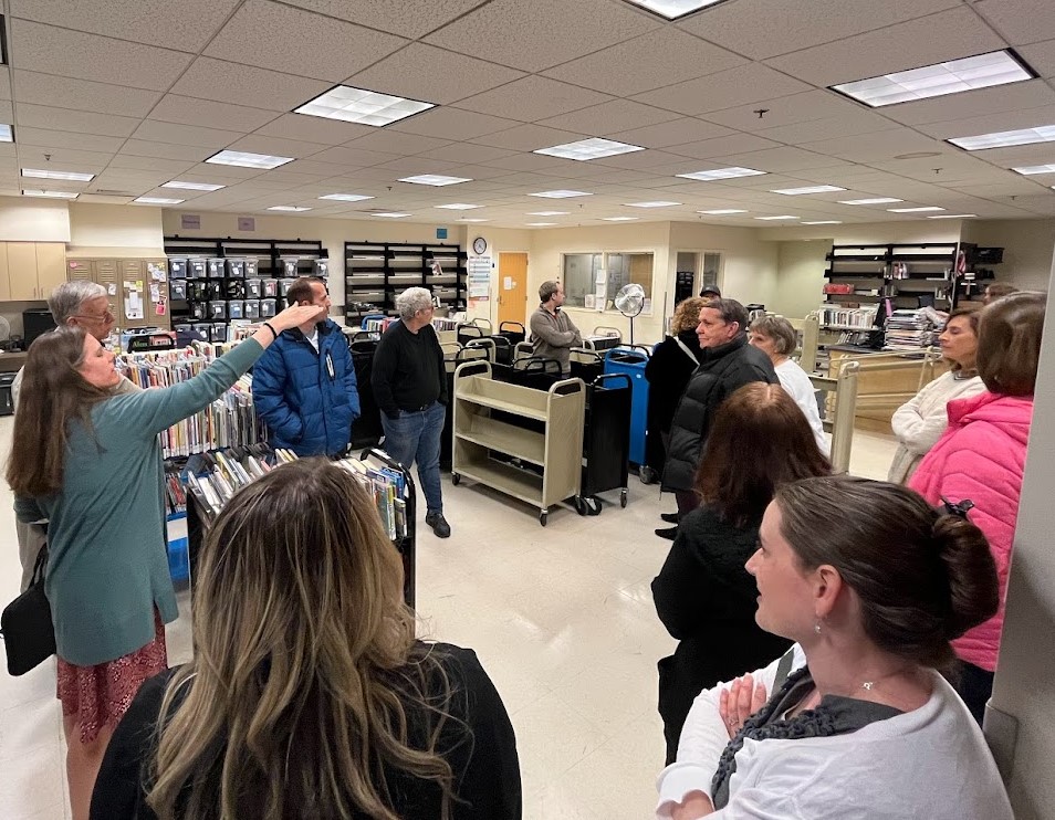 A group of adults listening to an instructor at the library