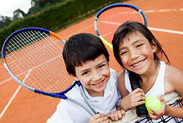 2 kids with tennis rackets